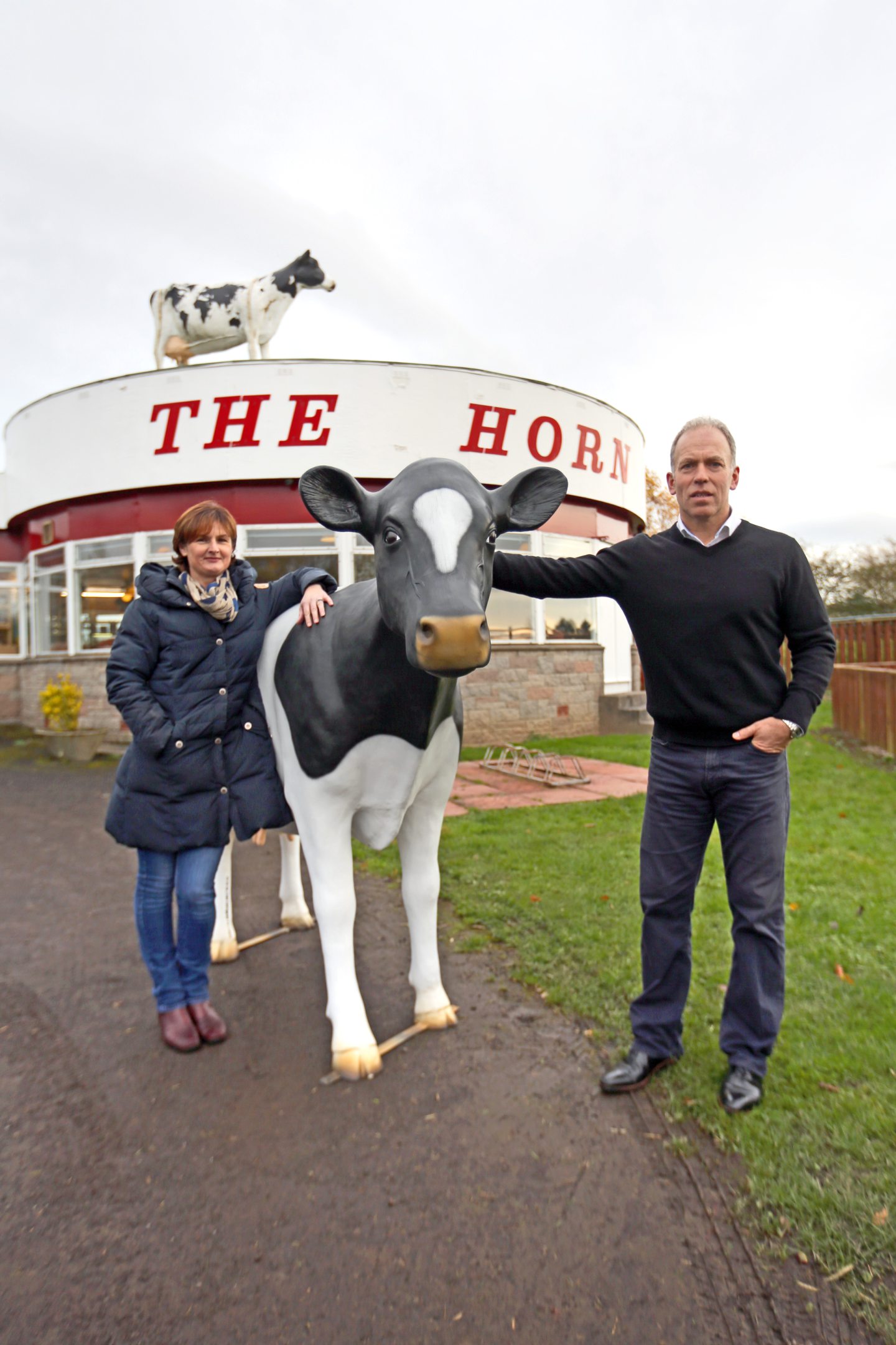 Julie and Kenny Farquharson, owner of The Horn, with a cow similar to the famous one that sits on the roof of the Milk Bar.